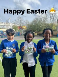 3 student holding Easter eggs smiling
