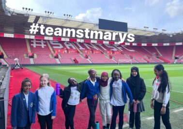 St. Mary's Church of England students in a football field taking picture
