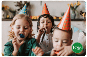 School children enjoying a noisy Christmas party with IQM-branding logo