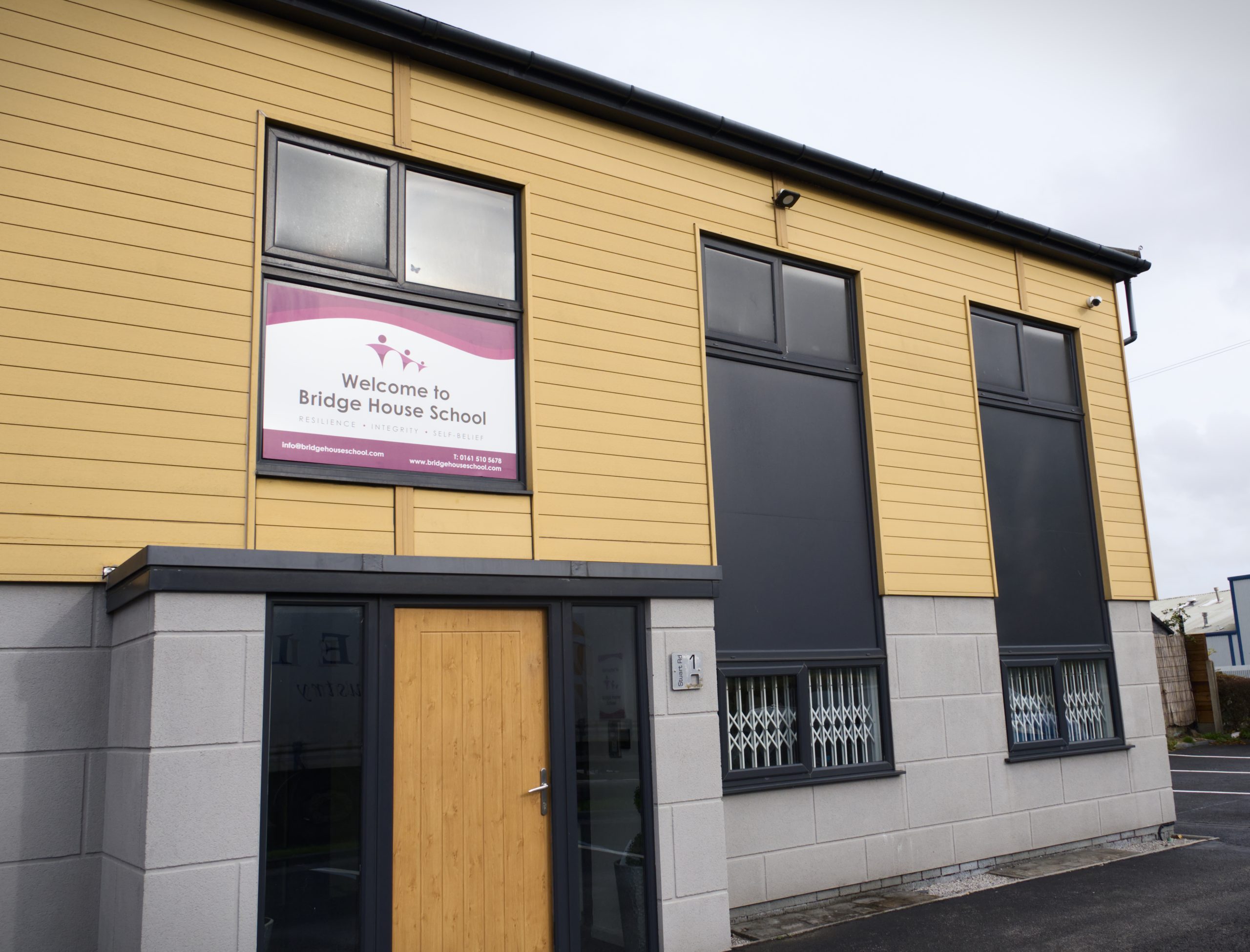 The outside of Bridge House School building with the name Birdge House in a window