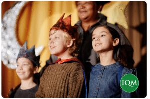 a group of children in the Christmas nativity play with IQM-branded logo