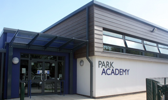 The outside of the Park Academy school building. It is a square building with a sign saying Park Academy