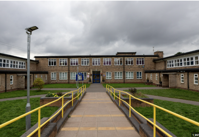 An image of the front of Northwood Park Primary school. showing a path leading to the front doors