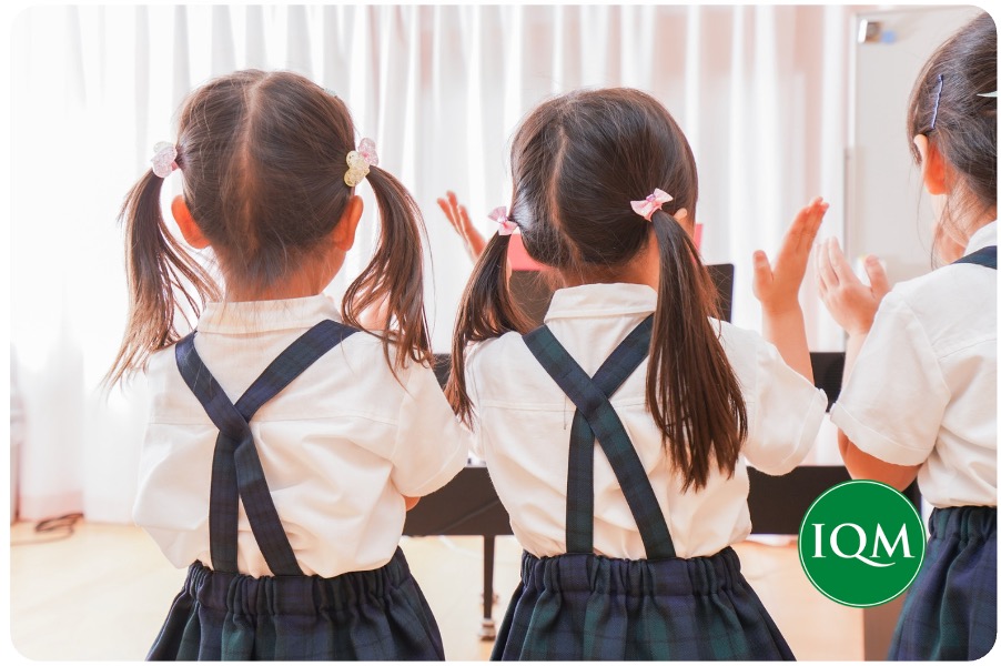 3 children in an international school kindergarten class in Dubai school clapping to music