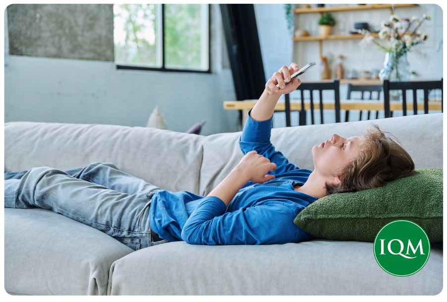 A teenage boy on his phone in peer WhatsApp groups
